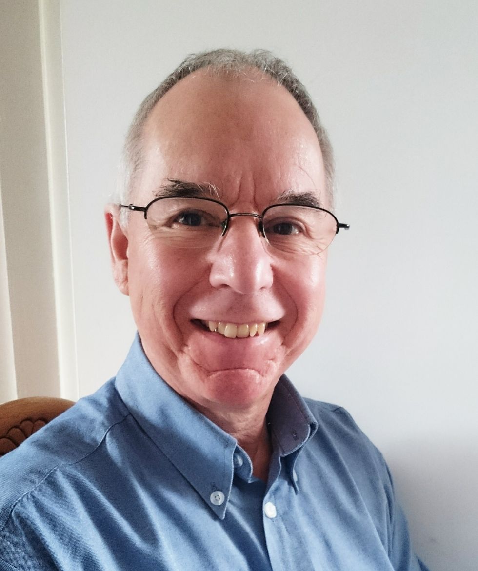 A headshot of Terry Hyde, wearing glasses and a blue dress shirt. He is smiling.