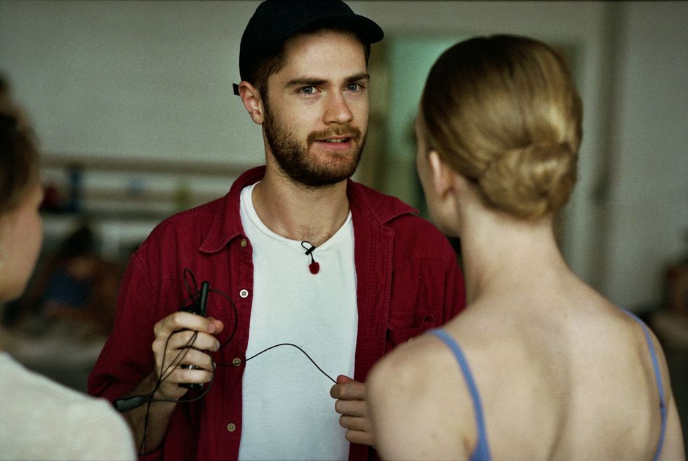 The film's director talks to the actor playing Lara. The actor's back is to us.