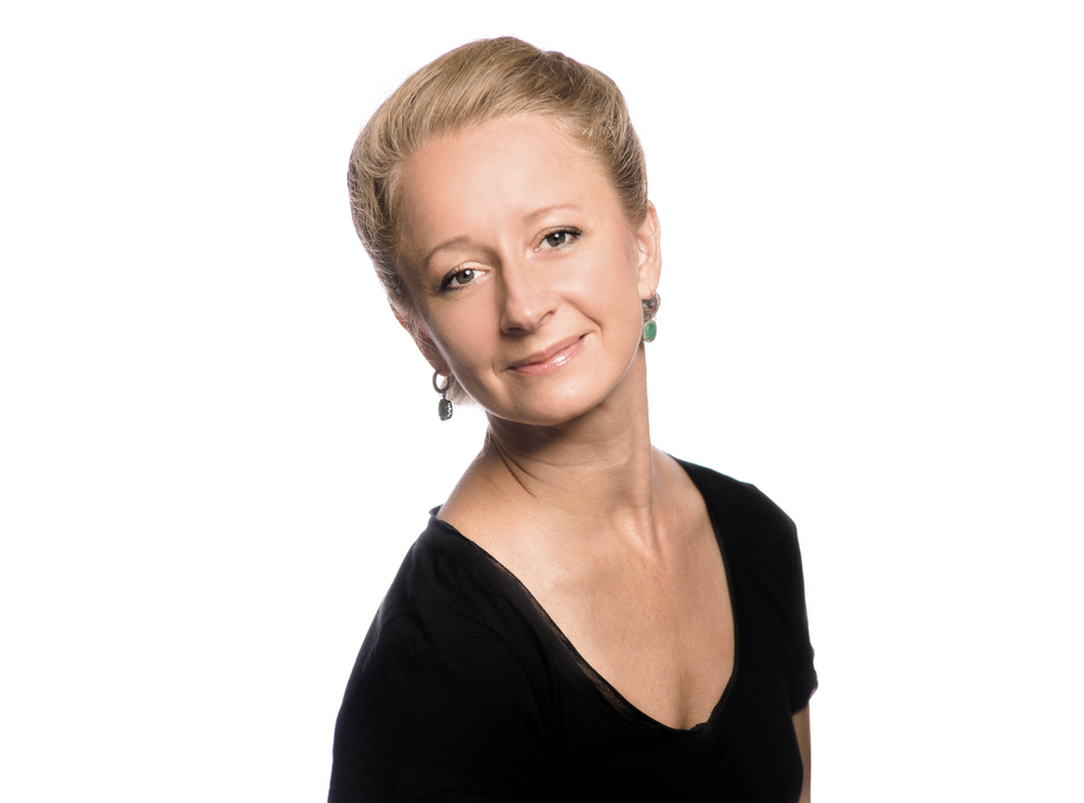 Headshot of Pomarenko in a black top and green earrings. She tilts her head to the side.