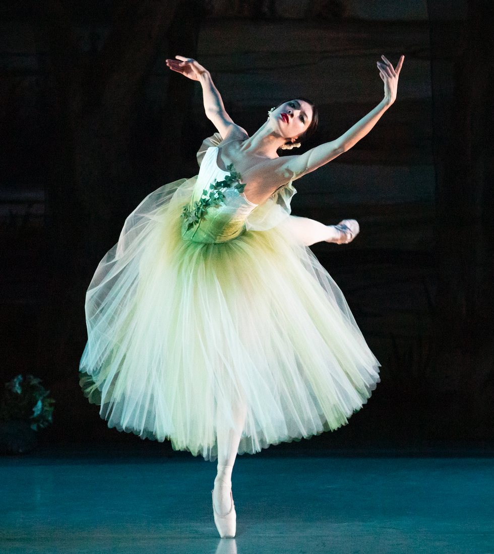 Neale in a greenish romantic tutu with leaves on the front, in a renversu00e9 on pointe onstage.