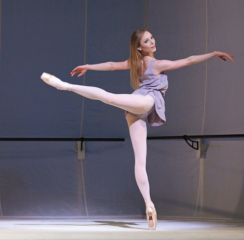 Lamb, in an arabesque onstage in pink tights and a pale purple practice dress.