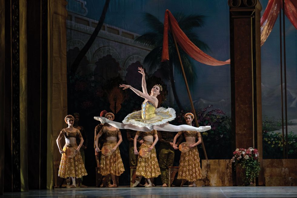 Dolan leaps through the air in a yellow and white tutu onstage