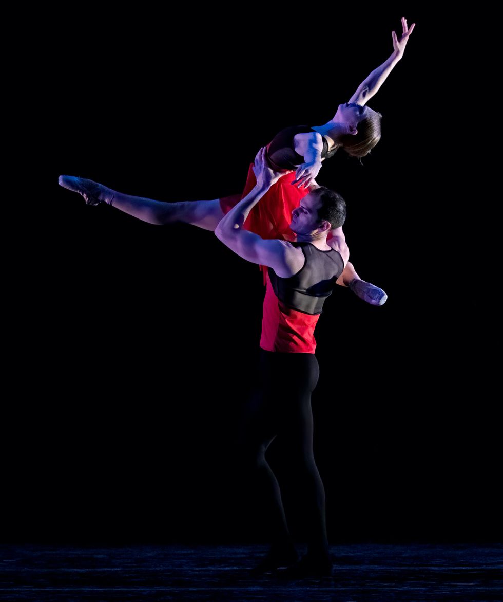 u200bAntonio u200bMorillo partners a female dancer, lifting her to shoulder height as she extends her front leg forward and arches her torso back.
