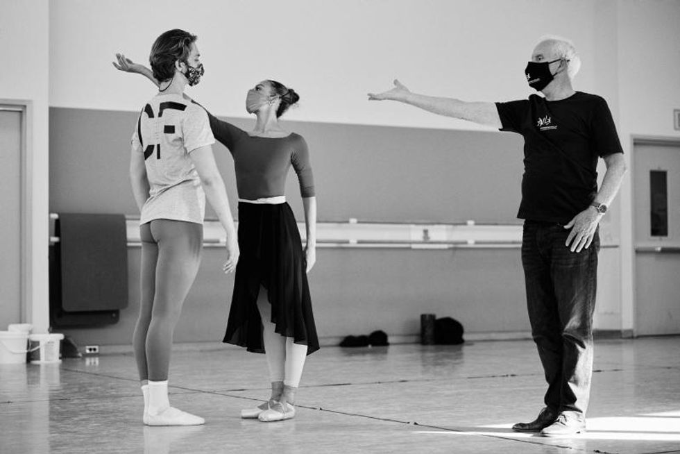 Nikisha Fogo stands in a studio with her right arm extended, wearing a leotard and long skirt