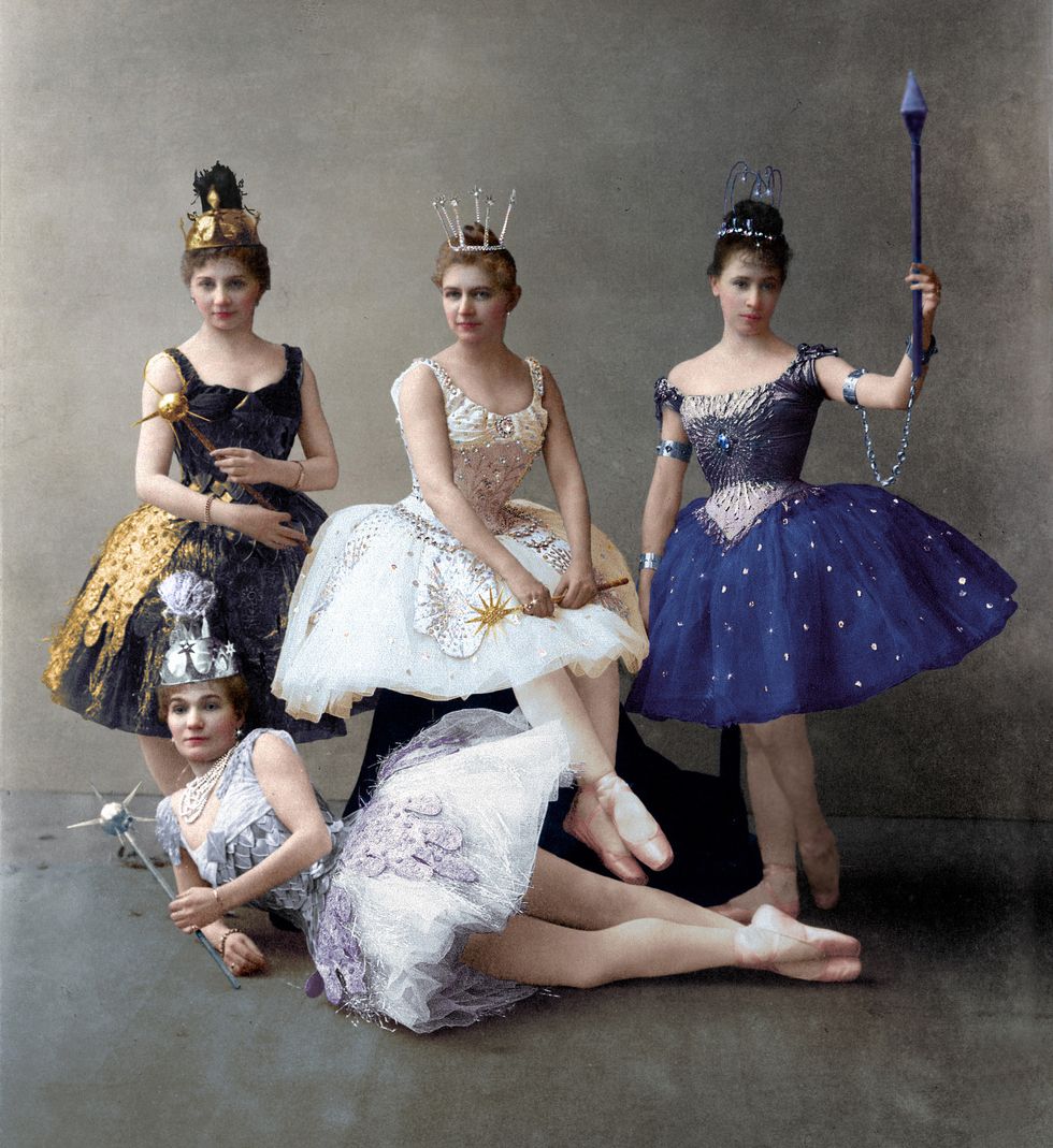 A ballerina in a lavandar tutu lounges on the ground, while three other ballerinas in tutus and crowns stand above her in B+.