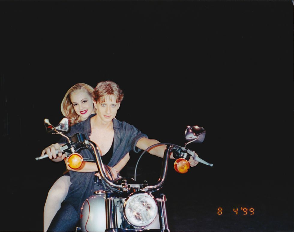Schull and Stiefel on a large silver motorcycle against a black background