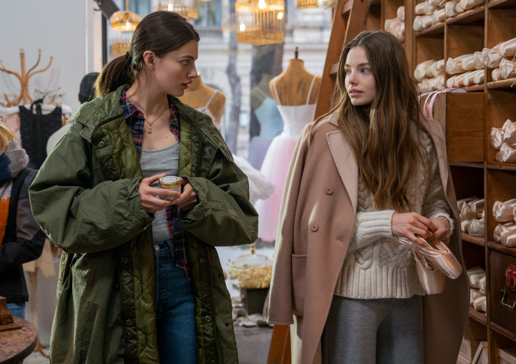 Diana SIlvers and Kristine Froseth, wearing jeans, sweaters and winter coats, talk as they walk through a dancewear store.