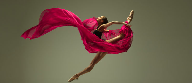 Graceful ballet dancer or classic ballerina dancing isolated on grey studio background. Woman with the pink silk cloth. The dance, grace, artist, contemporary, movement, action and motion concept.