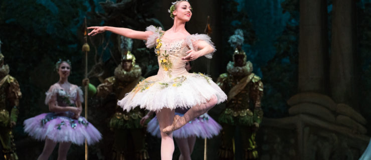 Tyler Donatelli balances onstage in retiré on pointe in a tutu and pointe shoes.