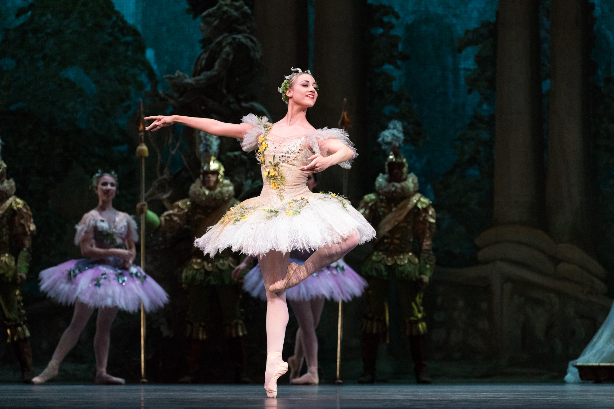 Tyler Donatelli balances onstage in retiré on pointe in a tutu and pointe shoes.