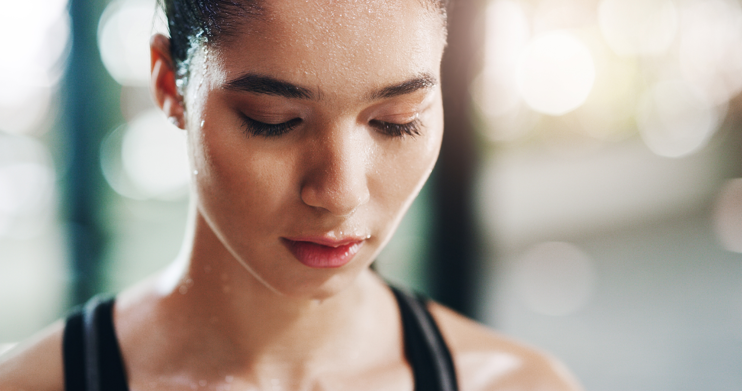 Closeup shot of a young female dancer looking hot, sweaty and tired with her eyes closed.