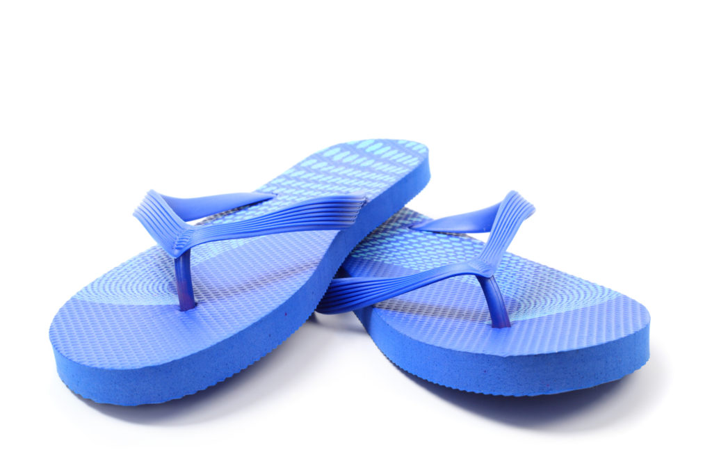 A pair of bright blue flip flops rests on a white background.
