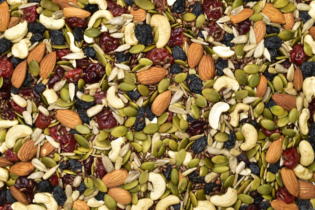 Trail mix fills the screen. Cashews, almonds, pumpkin seeds, sunflower seeds, dried cranberries, dried blueberries, and more are in the mix.