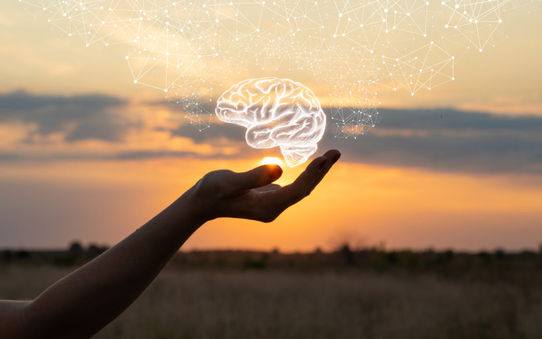 The silhouette of a woman's cupped hand is shown at sunset. A white illustration of a brain with constellations of thoughts sits just above the hand.