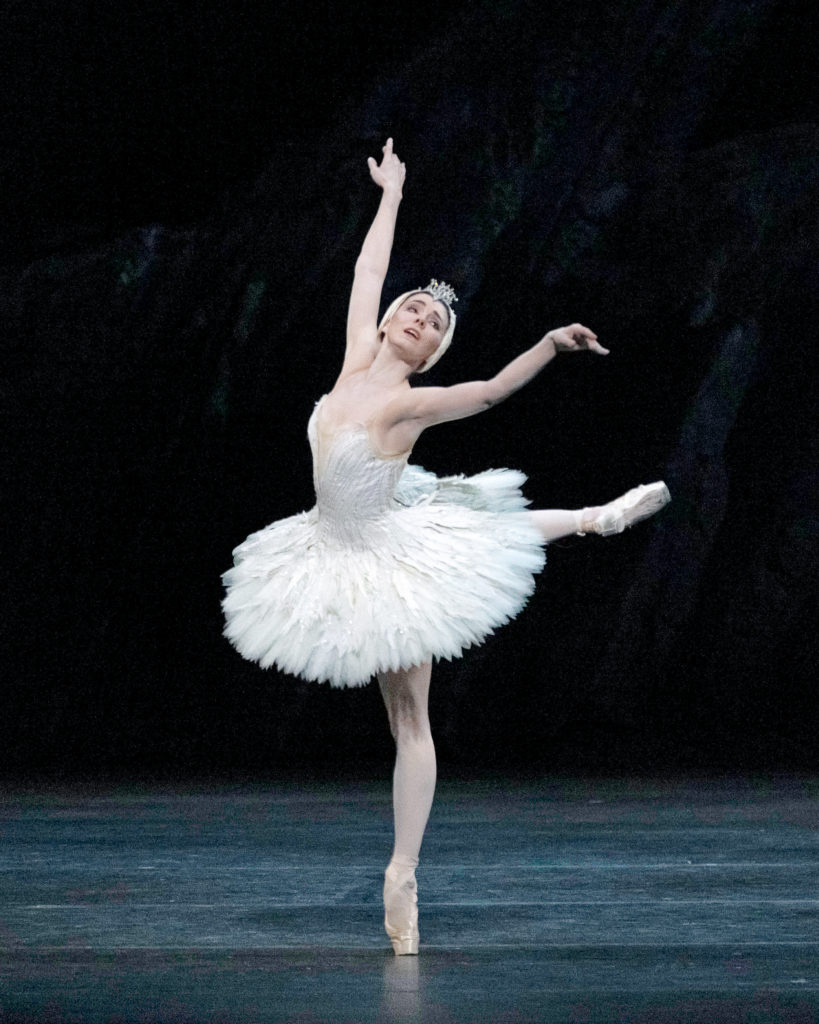 In a white pancake tutu and matching headpiece, Natalia Osipova extends in an exuberant arabesque as she performs "The Dying Swan" onstage.