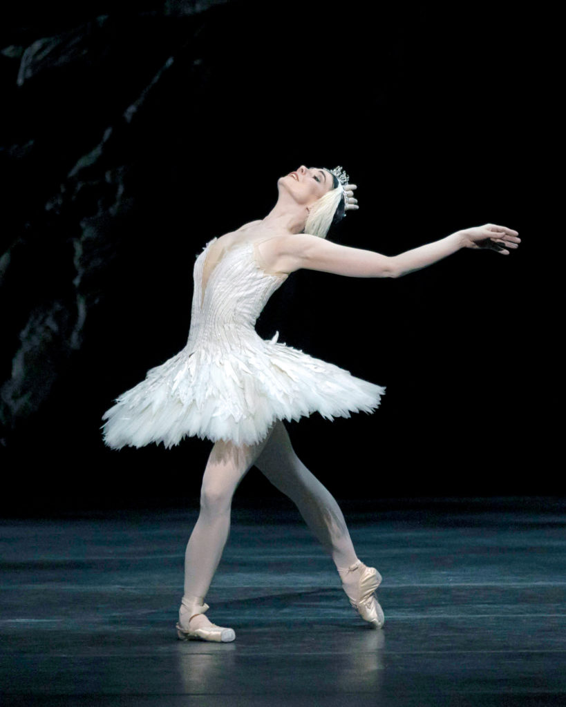 In a white pancake tutu and matching headpiece, Natalia Osipova arches back in a fondu tendu derriere, arms behind her like wings, as she performs "The Dying Swan" onstage.