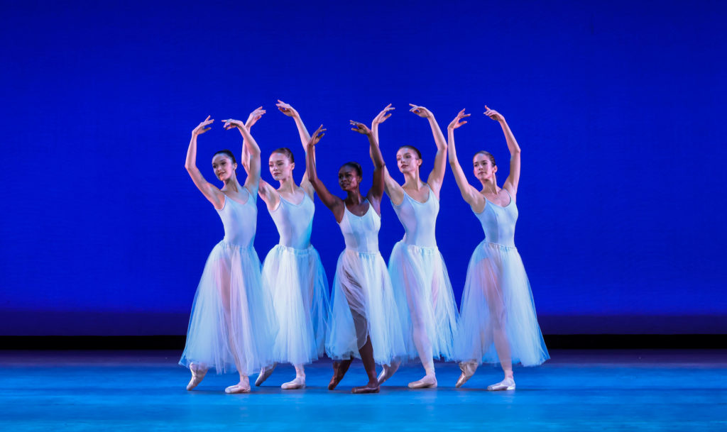 Five women in romantic tutus standing in B-plus with arms overhead in fifth.