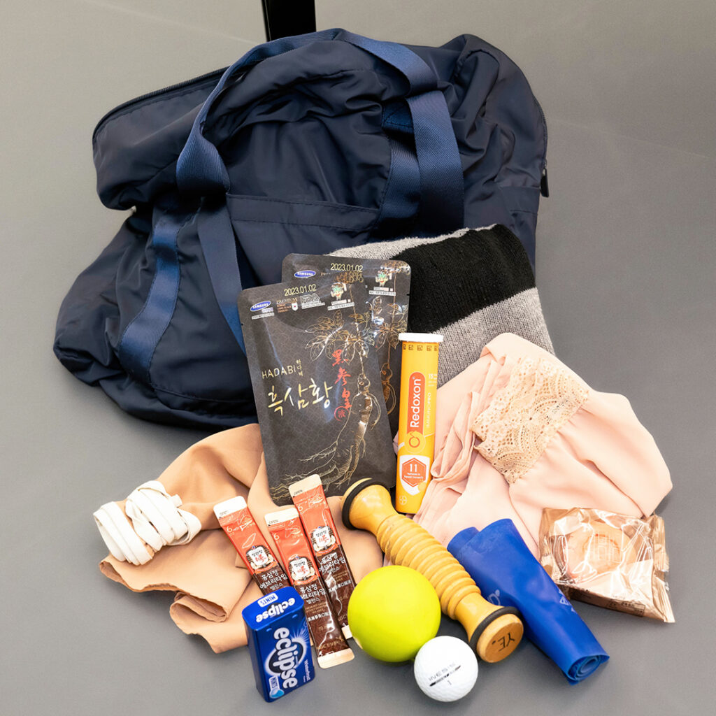 This is a photo of the contents of Ye Feifei's dance bag, arranged on the floor of a dance studio.