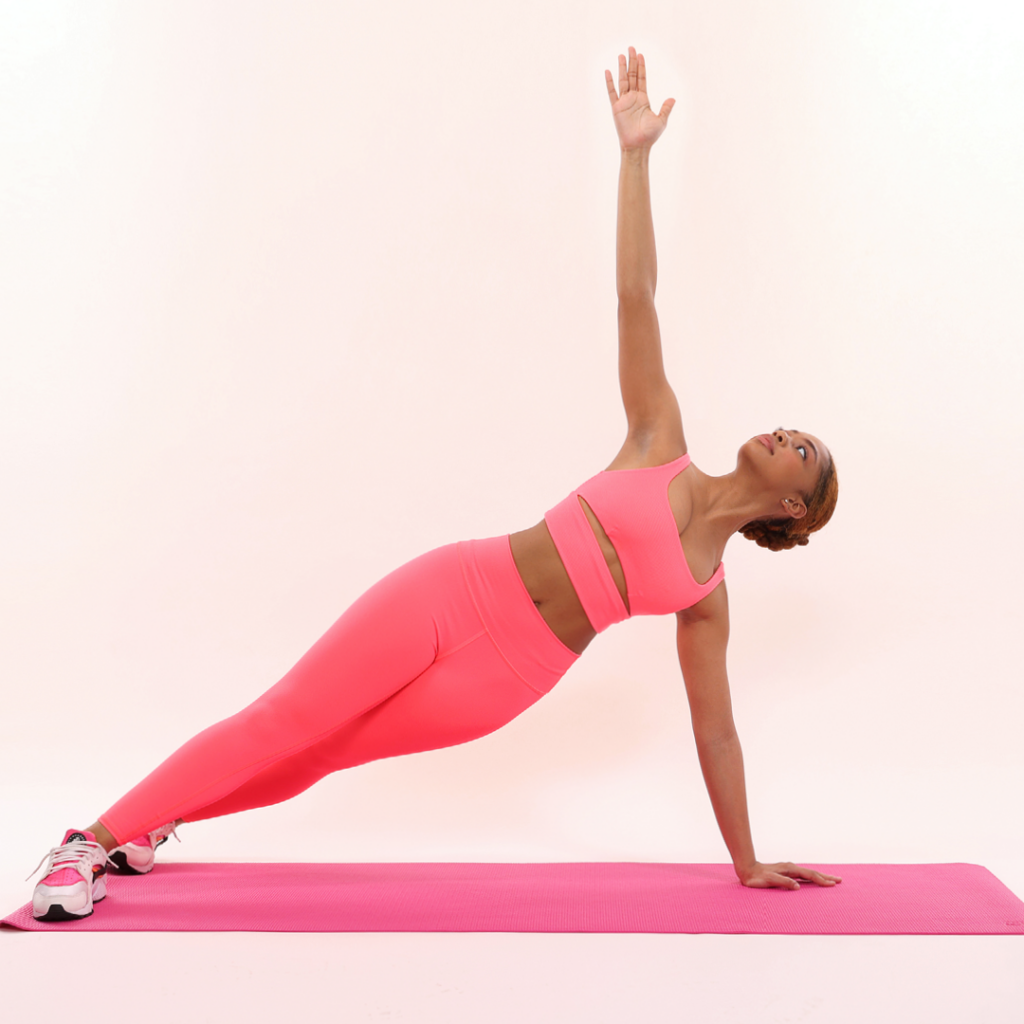 Model Azrielle Smith demonstrates the exercises as described. She is wearing pink leggings, a pink workout top, and pink, white, and black sneakers. She is using a pink mat.