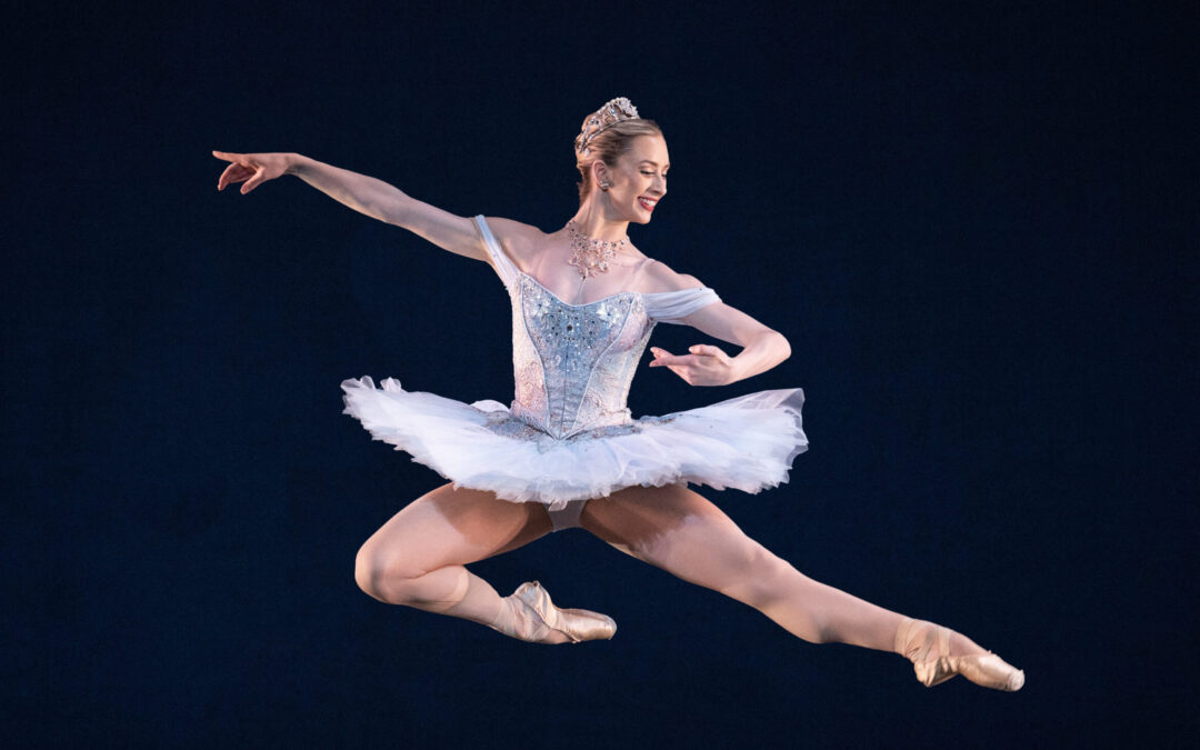 Tommie Lin O'Hanlon does a flying Italian pas de chat in George Balanchine's Theme and Variations. She wears a sparkling light blue pancake tutu.