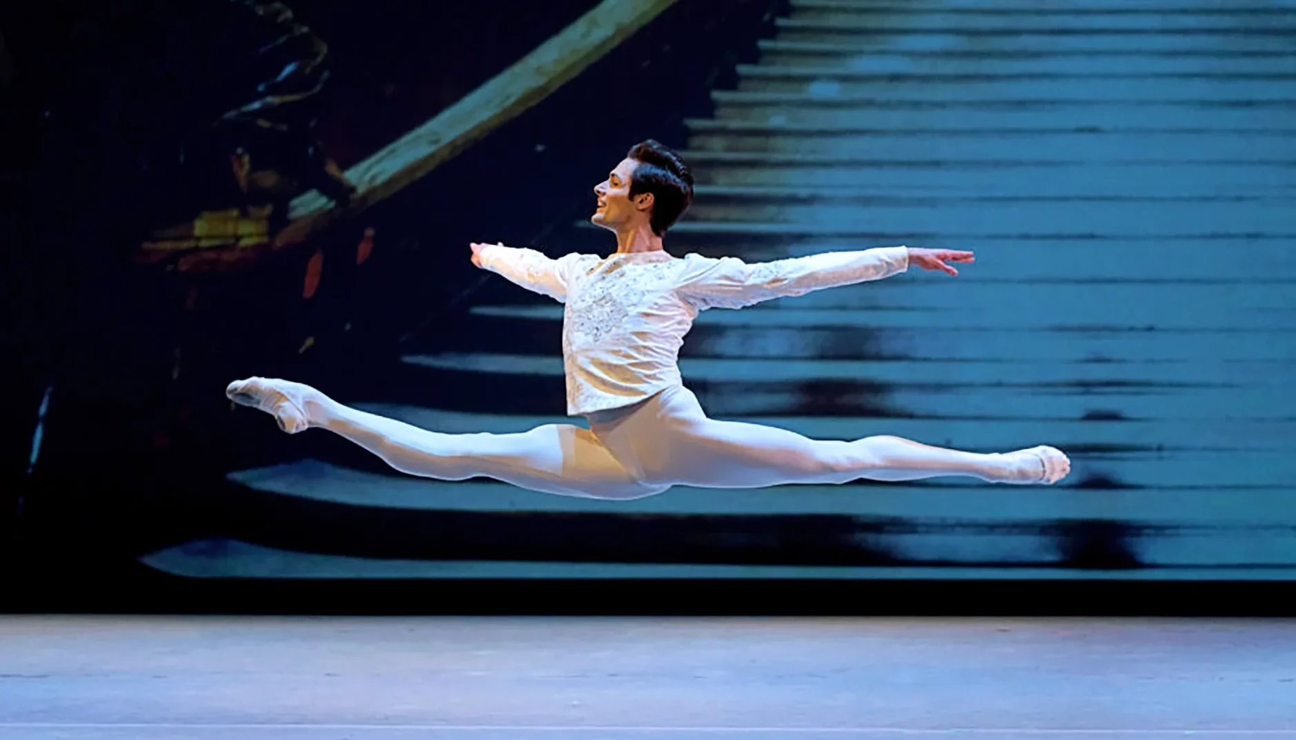 Jacopo Tissi flies through the air in a coupe jete en tournant, onstage in a princely costume.