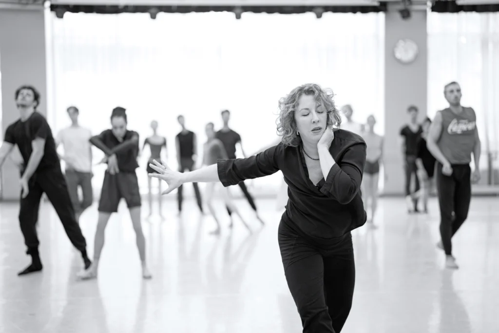 Helen Pickett leads rehearsal with dancers from The National Ballet of Canada in a large, brightly lit studio.