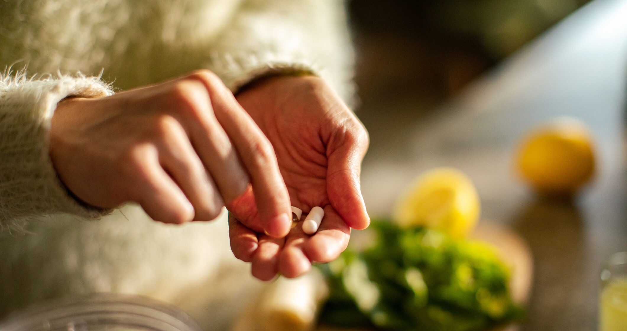 Close up of a Young woman taking a health supplement in the kitchen