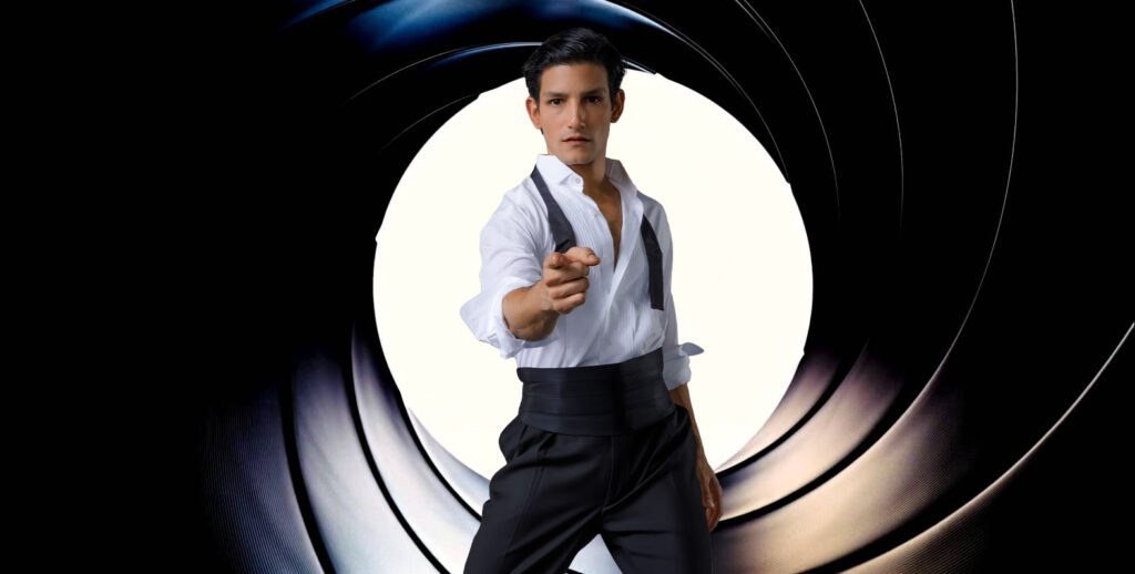 A man dressed as James Bond points intently toward the camera.