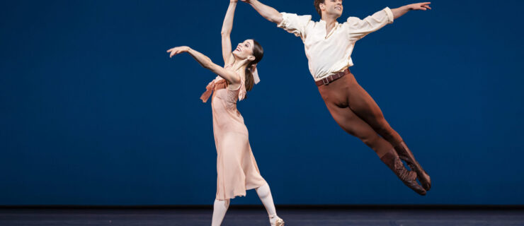 Alexander Campbell and Marianele Núñez perform an energetic pas de deux in "Dances at a Gathering." He wears a white tunic and brown tights; she wears a long flowing light pink dress.