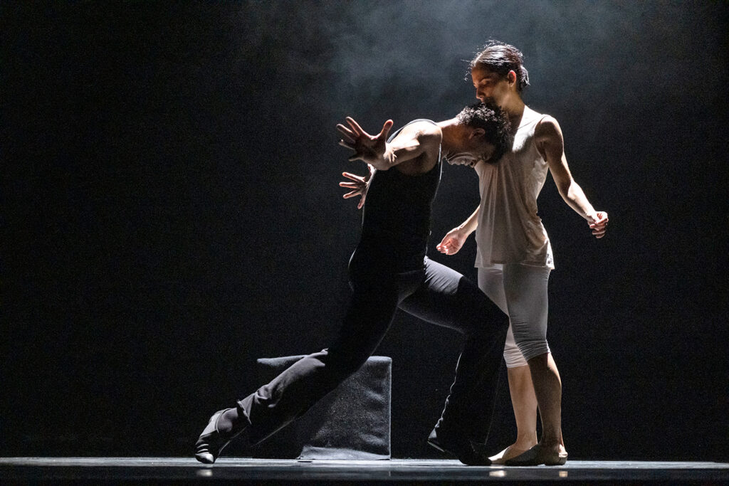 Carlos Acosta lunges forward and bends his head down to rest its crown on Laura Rodriguez's chest.