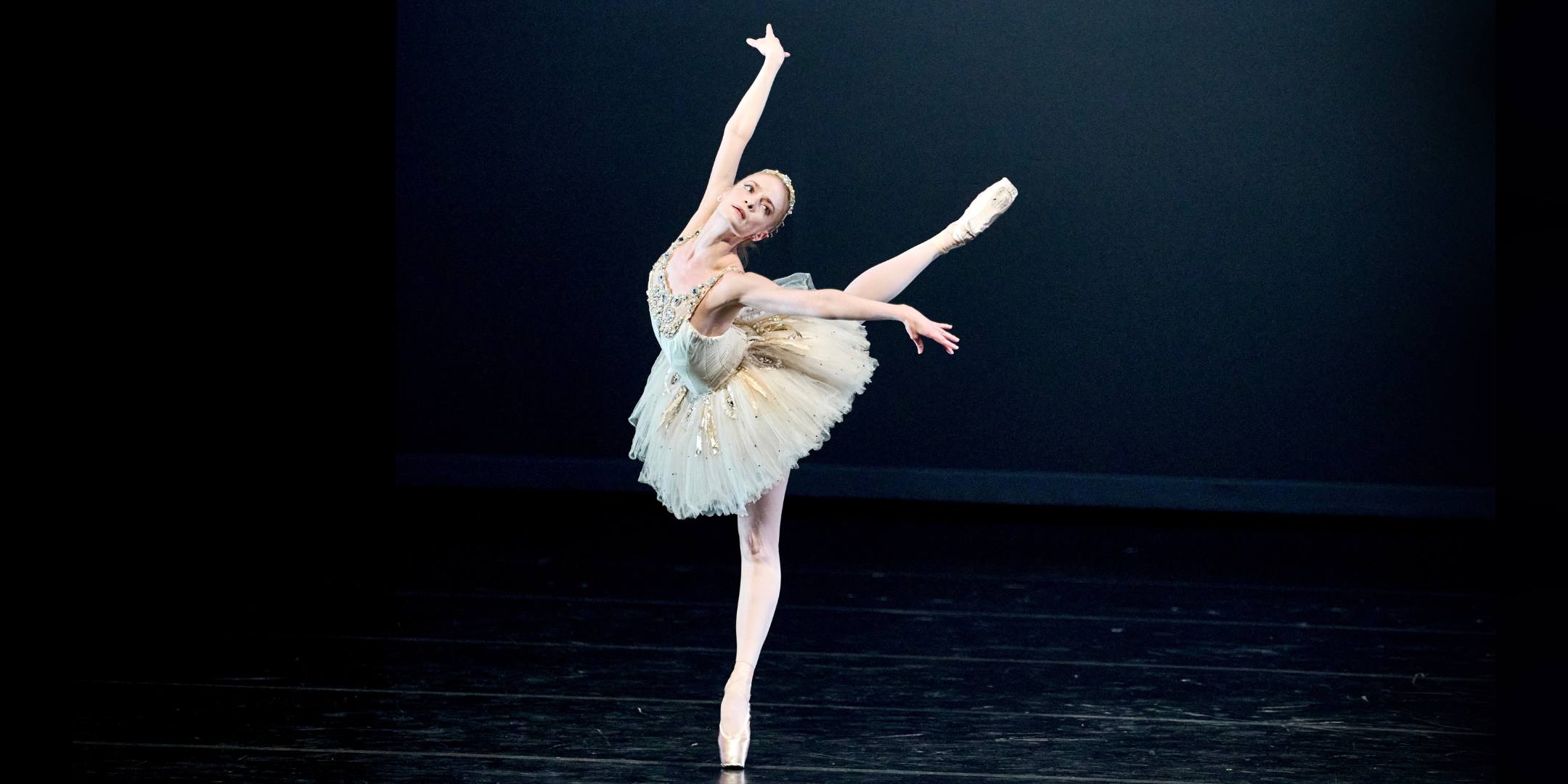 Sasha De Sola dances in George Balanchine's "Diamonds," standing in a beautiful arabesque croise on pointe.