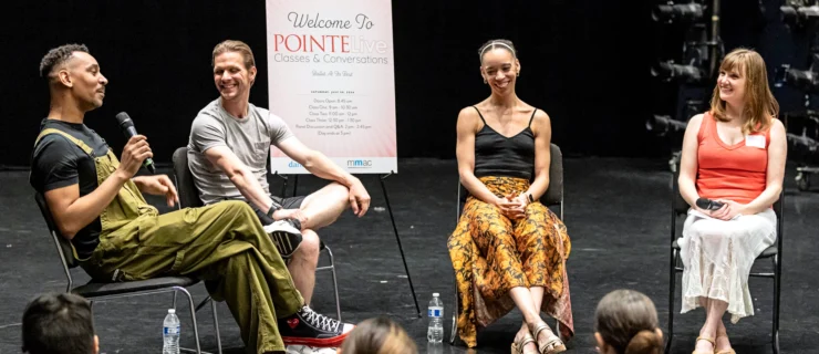 Clifford Williams, Daniel Ulbricht, Chyrstyn Fentroy, and Amy Brandt sit in a semicircle. Williams holds a microphone and the others watch him speak.