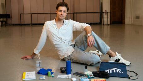 Jacopo Tissi lounges in a dance studio with the contents of his dance bag in front of him.