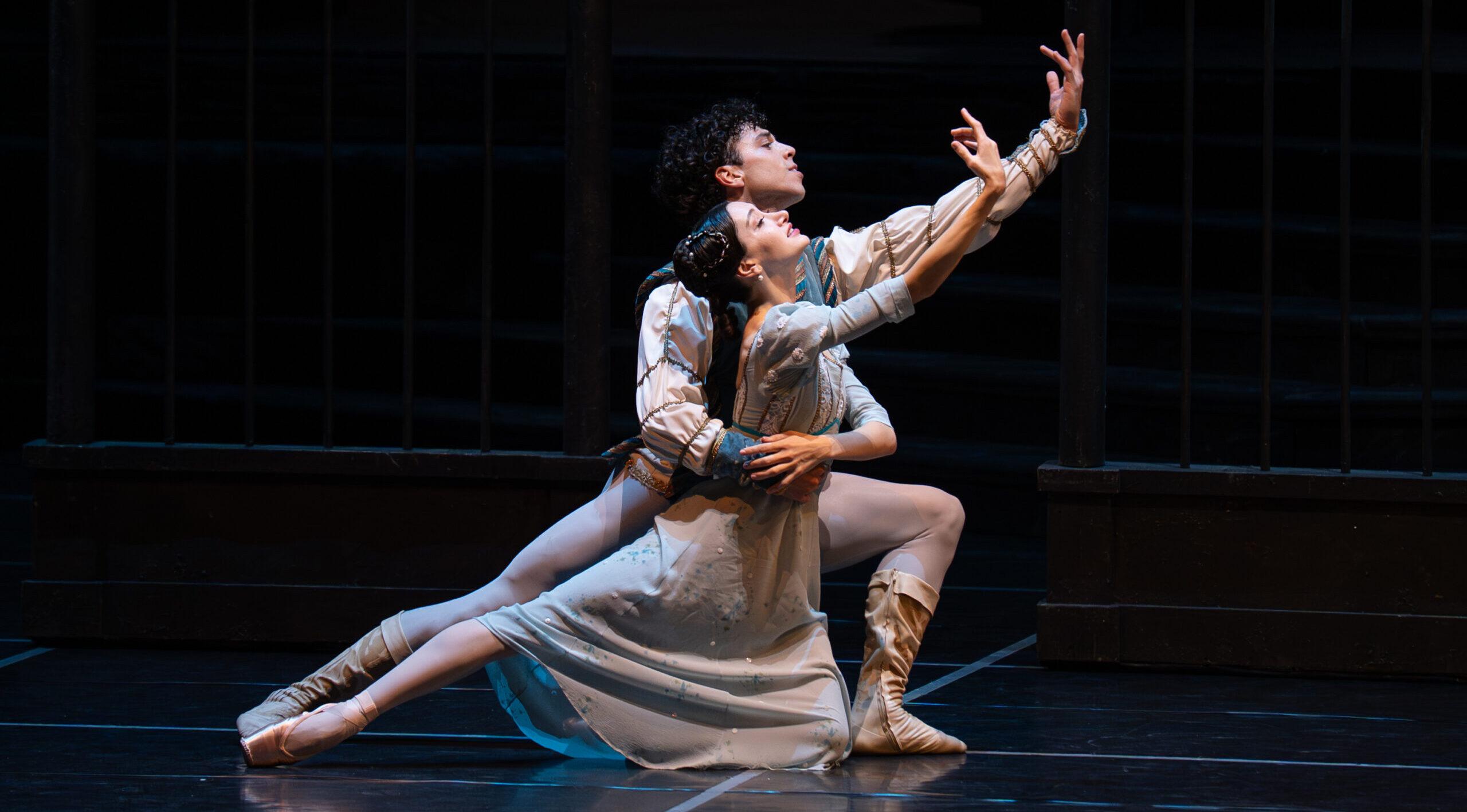 Salome Leverashvili dances with Timothy van Poucke on her left knee with her right leg extended back while van Poucke holds her waist lunging to the right on his left leg. Leverashvili arches her right arm to the front while van Poucke mirrors her with his left arm.