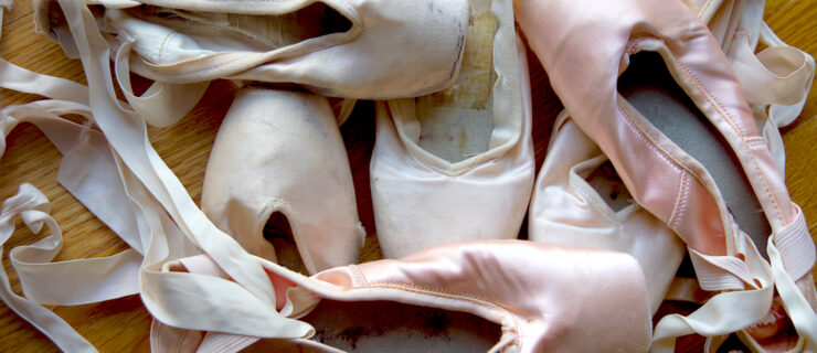 A group of well-worn ballet shoes.