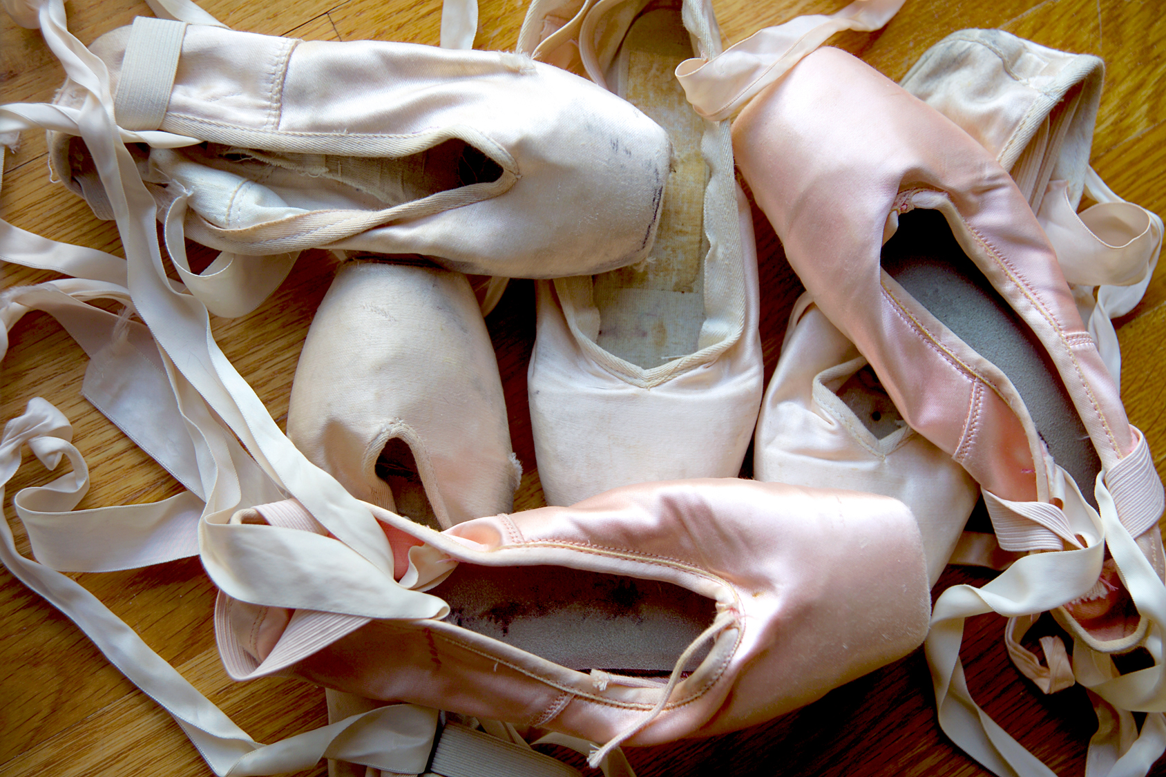 A group of well-worn ballet shoes.