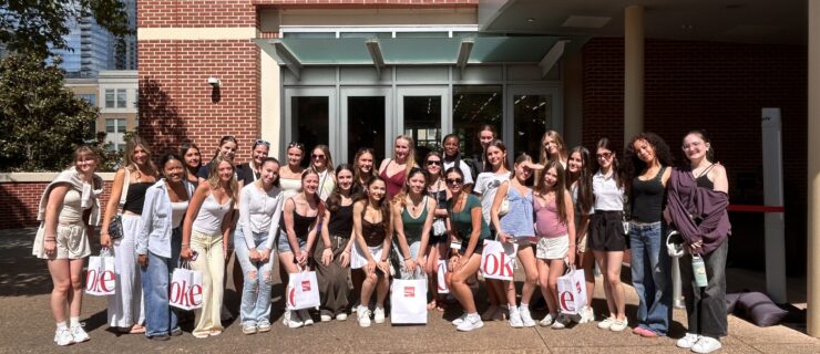 A large group of young dancers pose together together smiling.