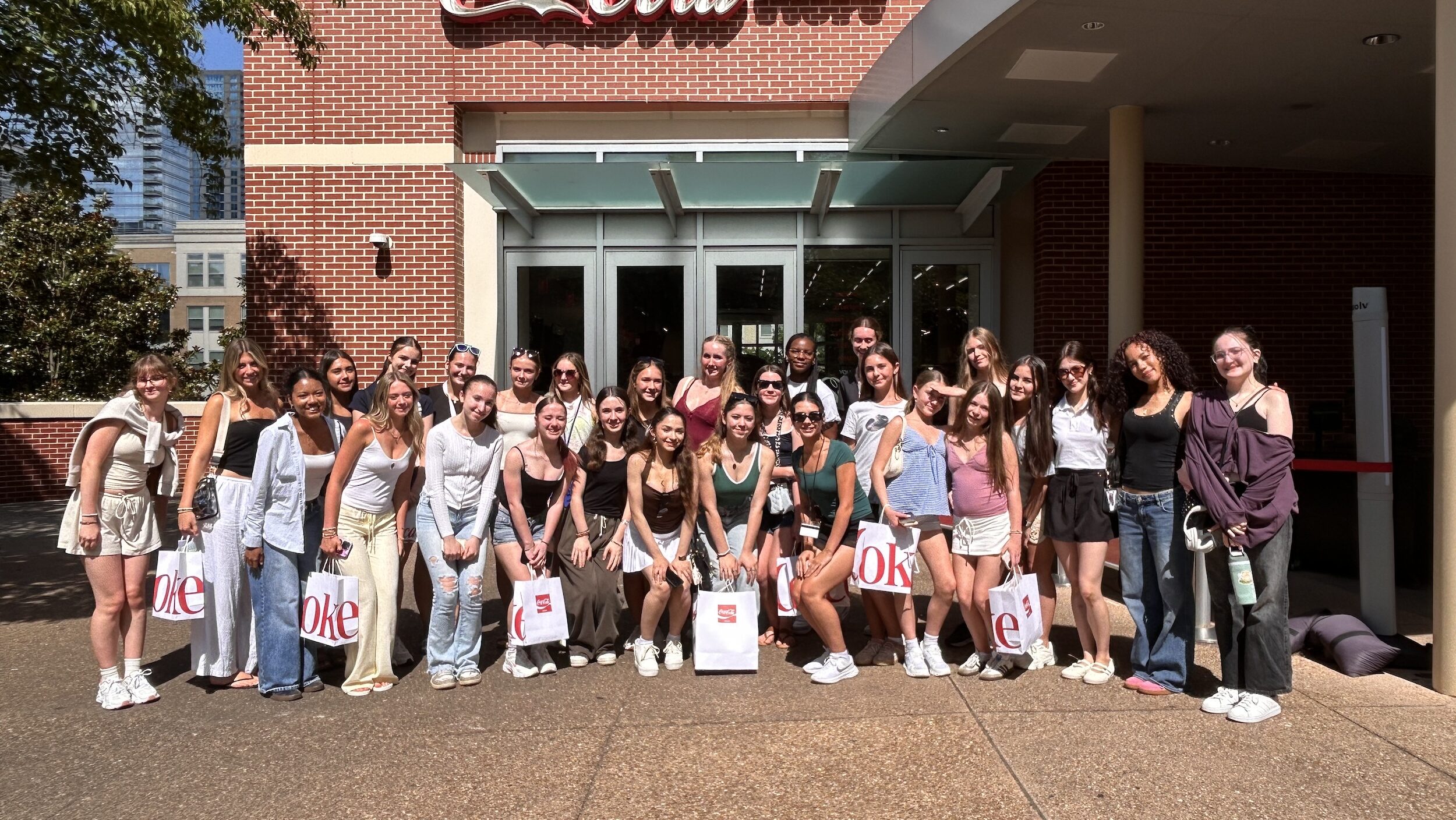 A large group of young dancers pose together together smiling.
