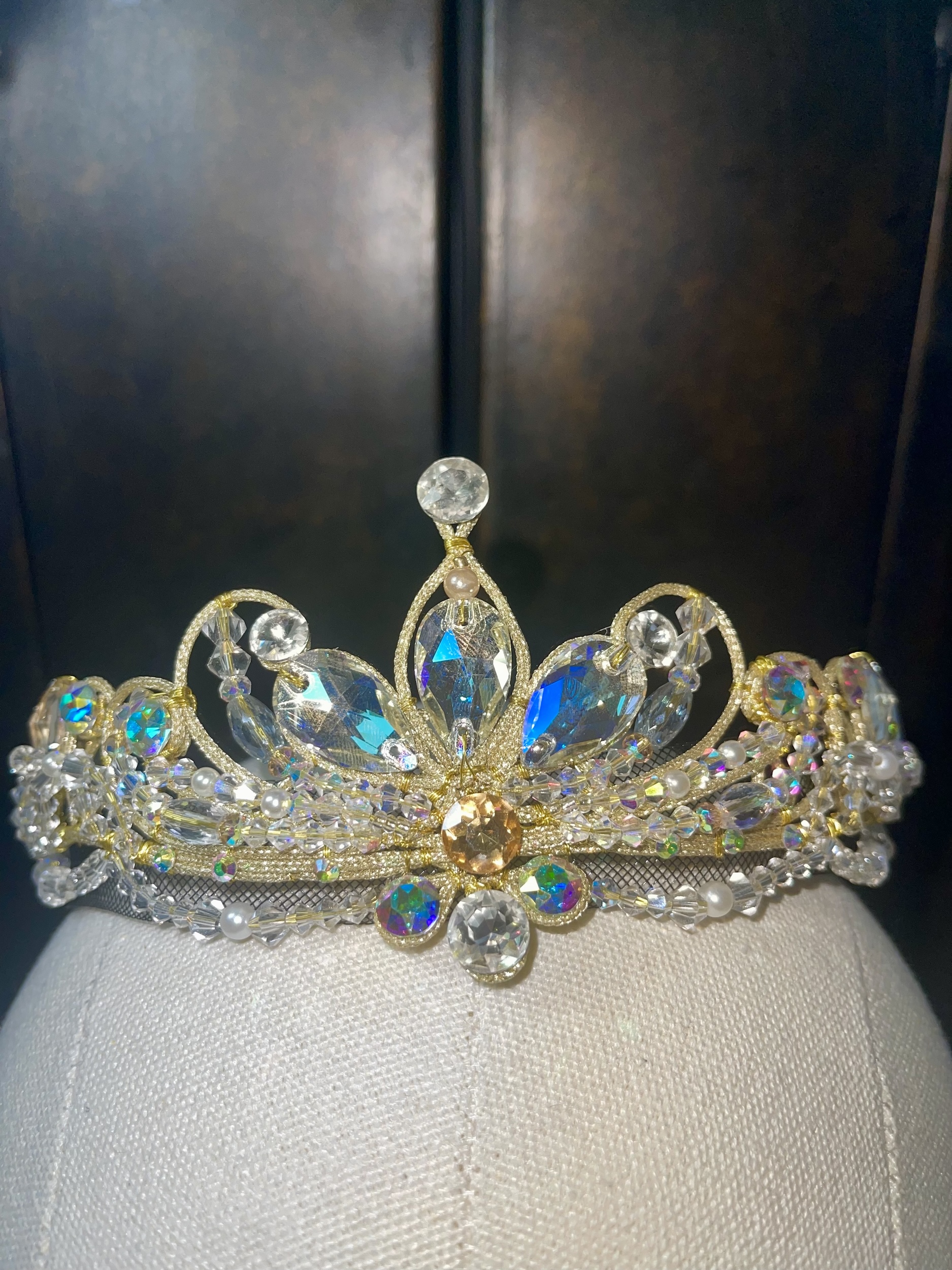 An intricate ballet costume tiara featuring iridescent blue and silver gemstones.