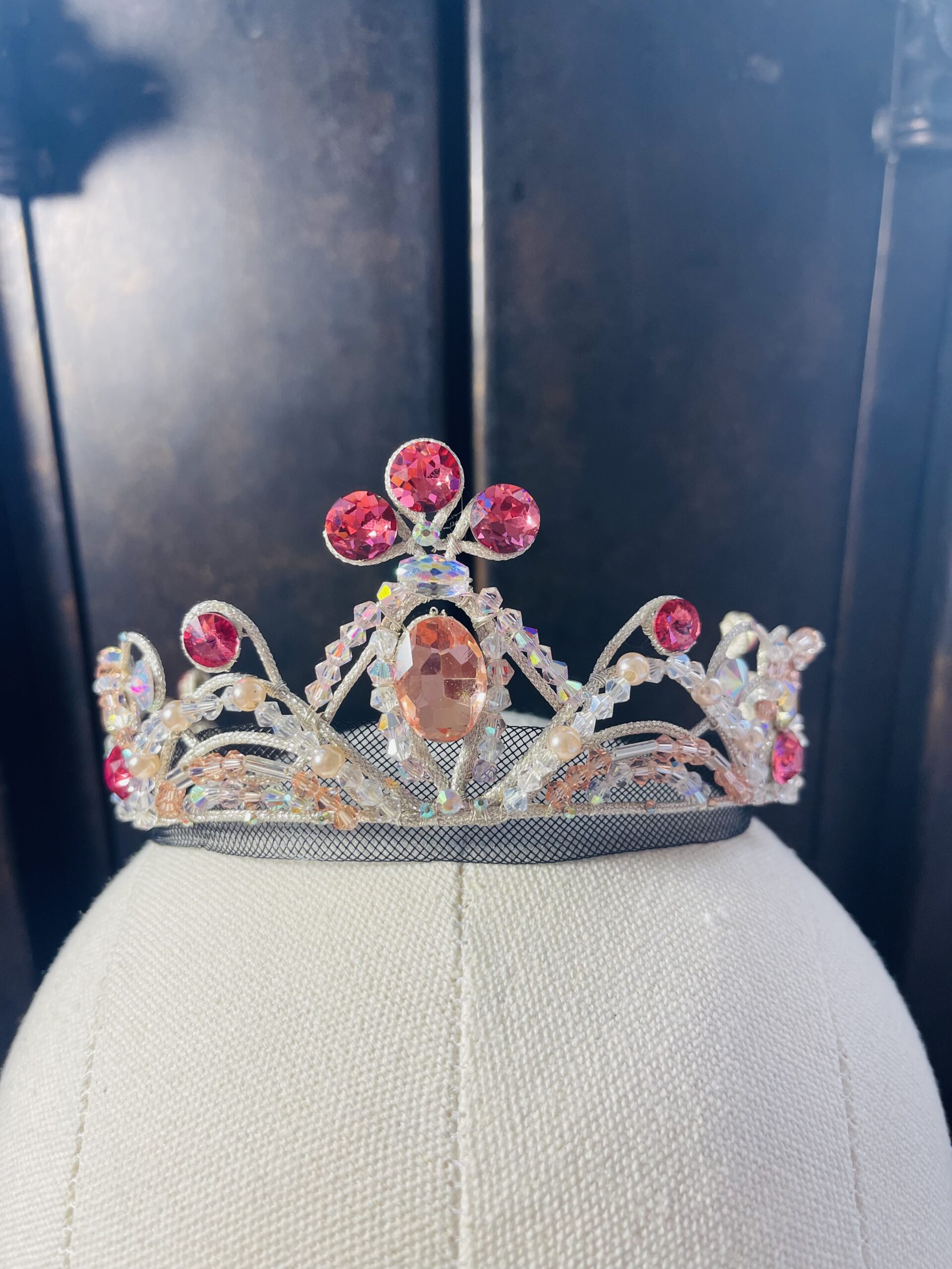 A ballet costume tiara featuring fake diamond, dark pink, and light pink gems.