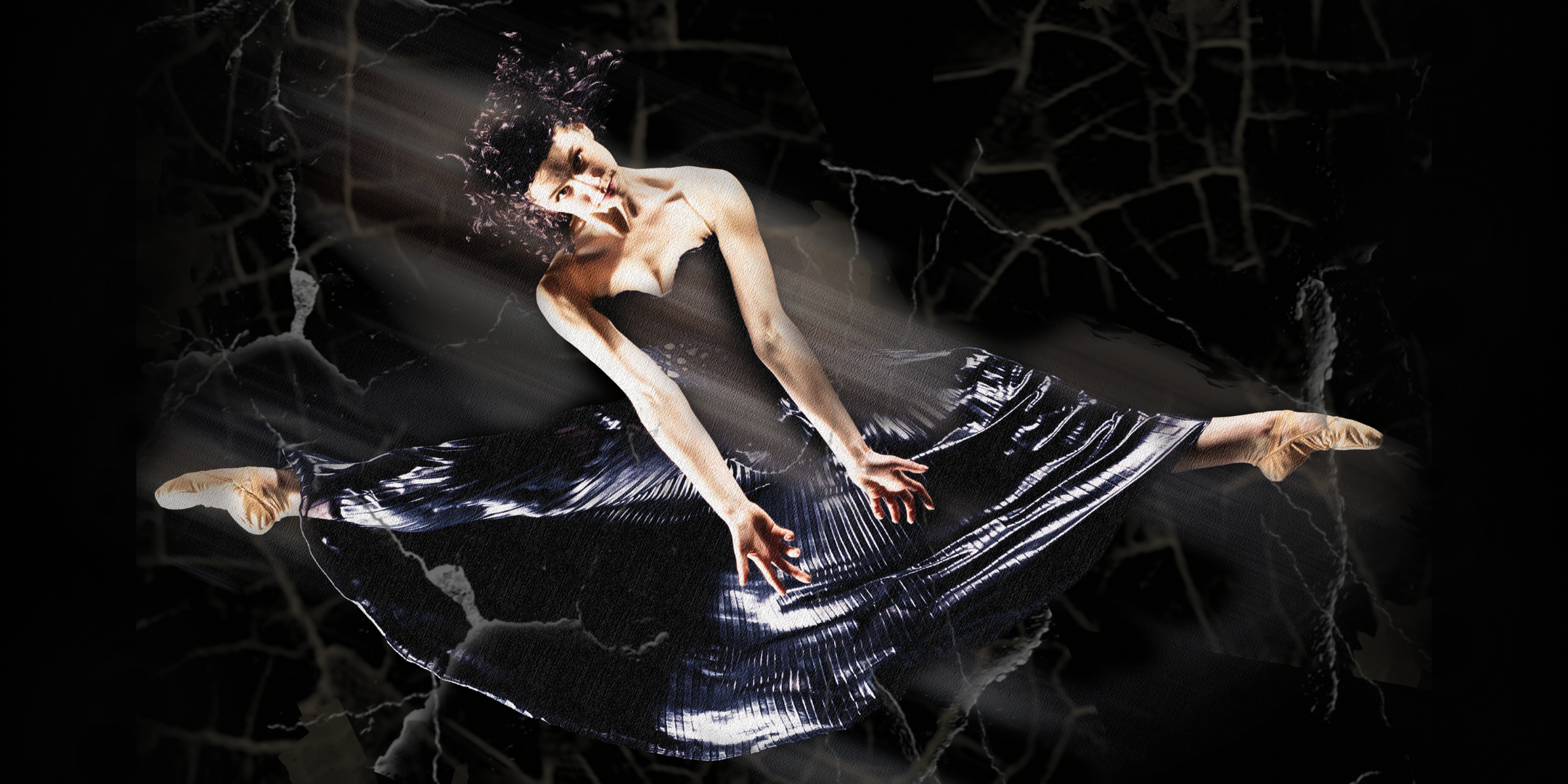Samantha Sherry is shown midair, in a side leap, against a black, spooky background. Her legs form a straight line. She wears a long black sleeveless dress and skin-tone ballet shoes. She throws her arms down in front of her, parallel with each other and in line with her torso, which she tilts toward the photo's left. Her curly hair is loose and she looks directly into the camera.