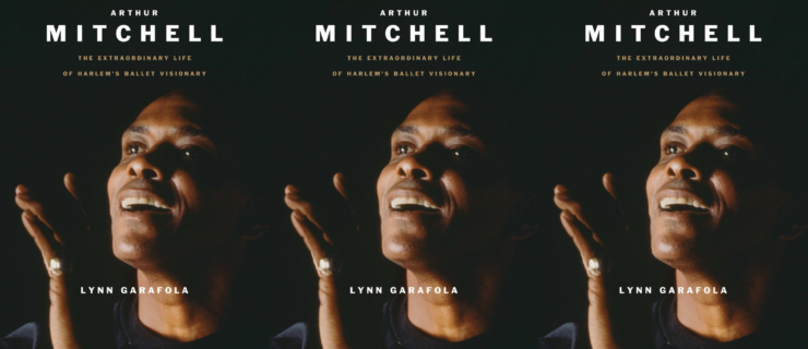 The cover of a biography titled "Arthur Mitchell: The Extraordinary Life of Harlem’s Ballet Visionary." On the cover is a photograph of Arthur Mitchell lit from the side against a dark background. He opens his mouth to speak with a pleasant expression, one hand raised with fingers gently bent.